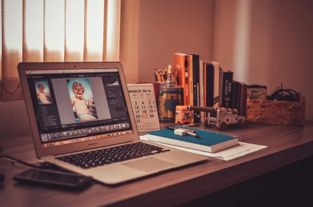 A laptop on a desk with a photo of a young boy