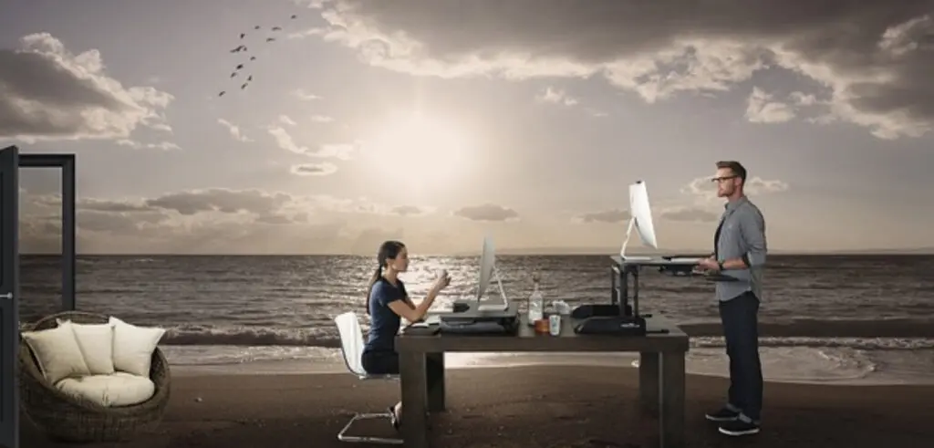 A man and woman sitting at a desk with a laptop, working together on a project