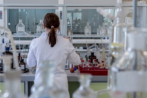 A woman in a lab coat working on a project